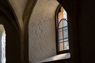 Derin duvar ve güneş ışığıyla kubbeli kale pencere yapısı.