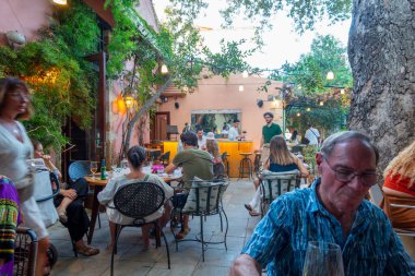 Chania - Girit - 17 Ağustos 2024; Yemeklerinin keyfini çıkaran restoranları olan yoğun avlu restoranı.