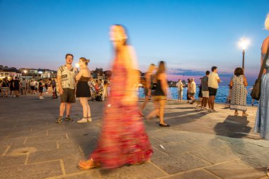 Chania - Girit - 17 Ağustos 2024; Geceleri uzun süre maruz kalan insanlar sıcak Akdeniz akşamının keyfini çıkarırken gezinti güvertesinde belirsizleşti.