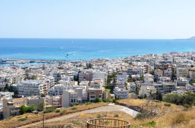 Yokuş aşağı, kıyı kasabası Rethimno 'daki yerleşim yerleri ve liman manzaralı Girit' in ötesinde deniz ve ufuk var..