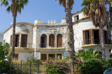 Terk edilmiş eski villa ön cadde çürümüş dış boyası, yıpranmış dış cephesi Kos Yunanistan 'da.