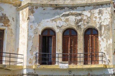 Terk edilmiş eski villa ön cadde çürümüş dış boyası, yıpranmış dış cephesi Kos Yunanistan 'da.