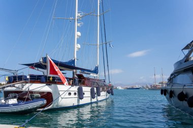 Kos Yunanistan - 21 Ağustos 2024; Lüks tekneler limanda ön planda büyük beyaz ketçap ile demirlediler.