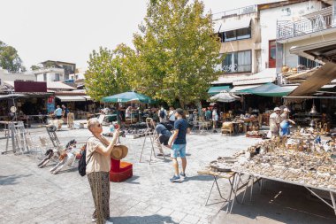 Atina Yunanistan - 30 Ağustos 2024; Habeşistan Meydanı bit pazarındaki gösterileri izleyen ve fotoğraflayan insanlar.