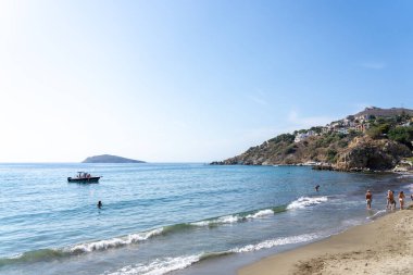 26 Ağustos 2024; Idyllic Kantouni Plajı yaz günü suda yüzücülerle..