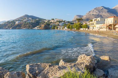Kalymnos Yunanistan - 26 Ağustos 2024; Dağlarla çevrili küçük körfezdeki Yunan Adası plajı manzarası.