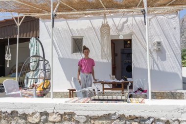 Telendos Yunanistan - 29 Ağustos 2024; Telendos Adası 'ndaki rıhtım sahnesi ve arka planda geleneksel balıkçı tekneleri ve ada tepeleri,