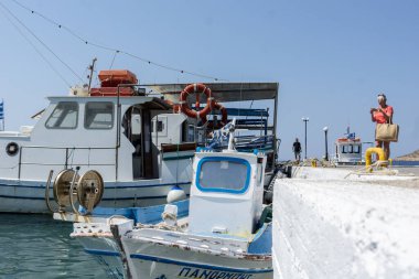 Telendos Yunanistan - 29 Ağustos 2024; Telendos Adası 'ndaki liman sahnesi geleneksel balıkçı tekneleri ve balıkçılarla.