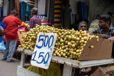 Colombo Sri Lanka - 2 Eylül 2024; Meşgul şehir pazarında el yapımı fiyat tabelasıyla Longan meyve satıcısı