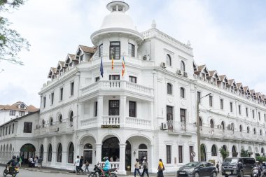 Kandy Sri Lanka - 4 Eylül 2024; Sömürge Kraliçesi 'nin tarihi binasının bulunduğu sokak köşesinde halk ve ulaşım.