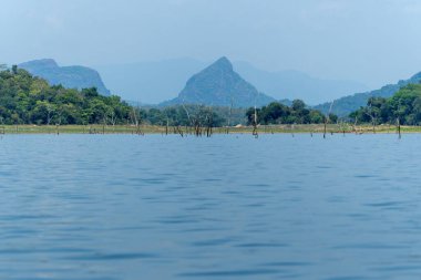 Mavi Gal Oya Gölü ve çevreleyen yeşil dağ manzarası Sri Lanka 'da ölü ağaçların kalıntılarıyla dolu..