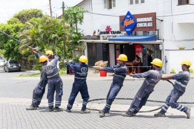 Galle Sri Lanka - 14 Eylül 2024; Seylan Elektrik İşçileri sarı sapkalarıyla sıraya girip elektrik hattını çekiyorlar.