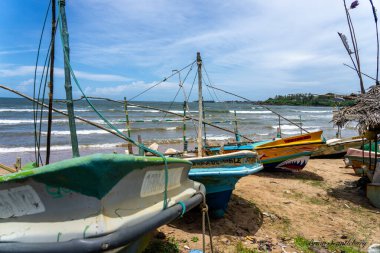Galle Sri Lanka - 14 Eylül 2024 Geleneksel pitoresk balıkçı tekneleri şehrin yakınındaki kumsalda ve Yeni Zelanda eğreltiotu amblemli bir sahilde çekildi.