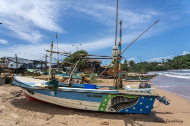 Galle Sri Lanka - 14 Eylül 2024 Geleneksel pitoresk balıkçı tekneleri şehrin yakınındaki kumsalda ve Yeni Zelanda eğreltiotu amblemli bir sahilde çekildi.