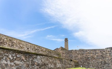 Mavi gökyüzünün altında, Galle Sri Lanka 'da beyaz bulutlu tarihi kale duvarları ve yeşil çimenler..