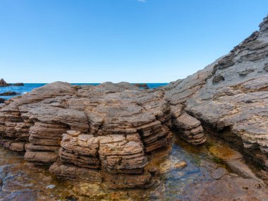 Yeni Zelanda 'daki Maunganui Dağı' nın eteklerinde yıpranmış kaya ve kaya havuzları..
