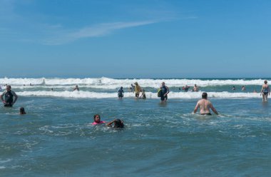 Maunganui Dağı Yeni Zelanda Aralık 2012; Omanu plaj sahnesi, Wade kumlarının ötesindeki suyun tadını çıkaran yüzücüler..