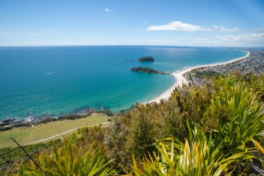 Maunganui Dağı 'nın tepesinden geniş kıyı manzarası. Uzun sahil sahili ve Yeni Zelanda adaları..