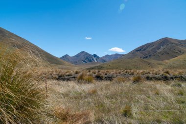 Lindis Geçidi 'nin çorap kaplı vadileri ve Yeni Zelanda' nın ünlü otoban şehri arasında mavi gökyüzünde mercek parlıyor..