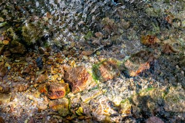 Dalgalar ve gölgeler sığ ve berrak sularda El Questro Boğazı 'ndaki gölün dibini taşa çevirdiler..