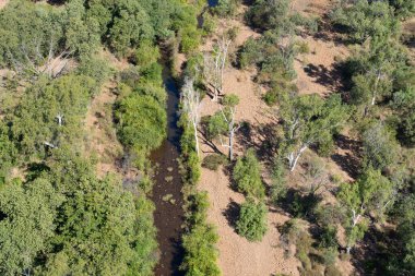 Kimberley Bölgesi 'nin dik kırmızı kayalık yüzleri güneş tarafından aydınlatılıyor. Batı Avustralya' nın üzerinde ay yükseliyor..