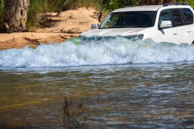 4x4 araç Batı Avustralya 'nın taşrasında nehir boyunca veya içinden geçiyor..