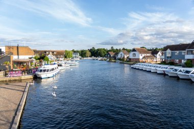 Wroxham Birleşik Krallık - 6 Temmuz 2025: Bure Nehri boyunca bulunan rıhtım, tekne ve binalar.