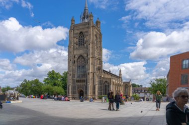 Norwich Birleşik Krallık - 8 Temmuz 2025; Gotik Kilisesi 'nin editör-uzun kulesi ve avluda insanlar ve yukarıda bulutlu gökyüzü.