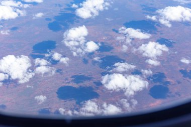 Beyaz kabarık bulutlar Avustralya 'nın kırmızı merkezi üzerine gölge düşürüyor..