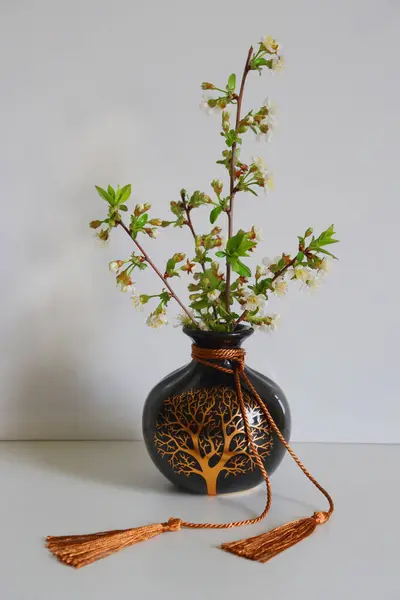 Masanın üzerinde dekoratif vazoda ağaç dalı