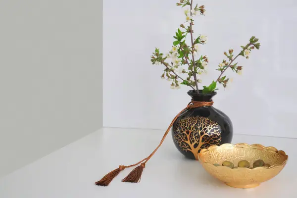 Masanın üzerinde dekoratif vazoda ağaç dalı