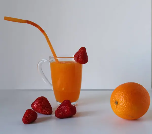 Masa arkasında portakal suyu olan taze meyve suyu.