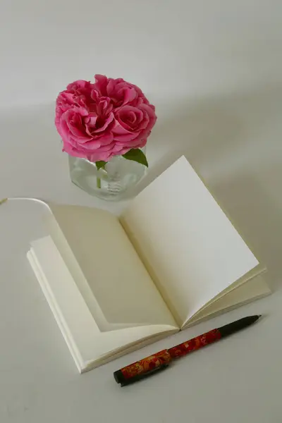 bir kitap ve pembe güller ahşap bir masada