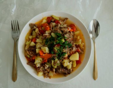 Sebzeli et ve tabakta beyaz bir tabakta et.