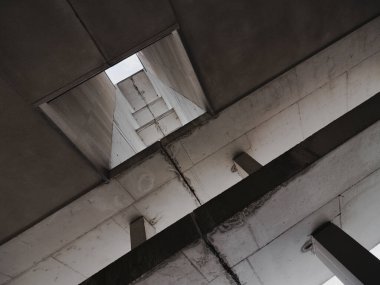 Birkaç sütunlu ve gökyüzü manzaralı bir şehir binasının genel planı. İnşaatın renkleri gri.