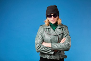 Çekici genç sarışın kadın kollarını kavuşturup kameraya bakar ve güzel, pozitif bir kadın gülümser. 