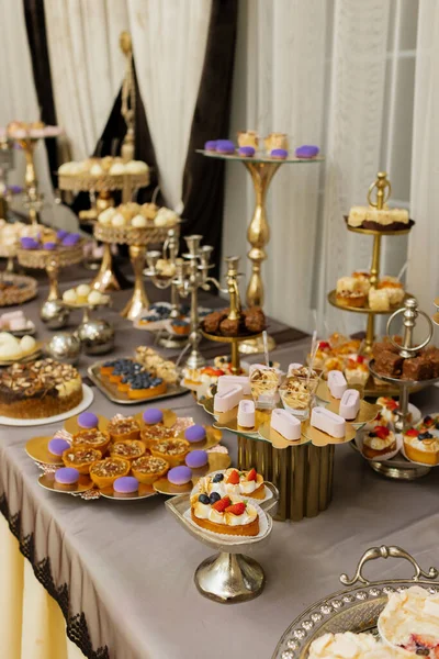 Table with cakes, sweets, candy, buffet. Dessert table for a party goodies for the wedding banquet area. Close up candy bar.