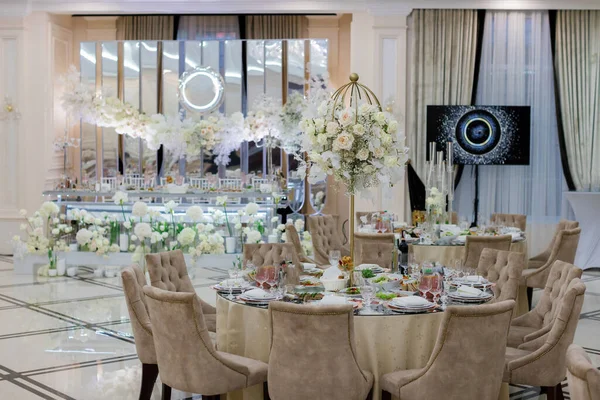Tables setting at a luxury wedding. Table for guests. Dishes and drinks. Wedding table preparation.
