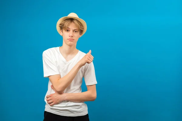 stock image Young caucasian boy wearing white t-shirt pointing to the back behind with hand and thumbs up