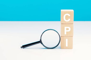 CPI - Tüketici Fiyat Endeksi sembolü. Harf bloğu kelime CPI kısaltması ile mavi arka plan üzerinde büyüteç ile. Kopya alanı. İş ve CPI, tüketici fiyat endeksi kavramı
