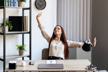 Smart business woman in formal suit outfit sitting and stretch relax in front of computer with happy and smile in modern office workplace. Young businesswoman relaxing in office.