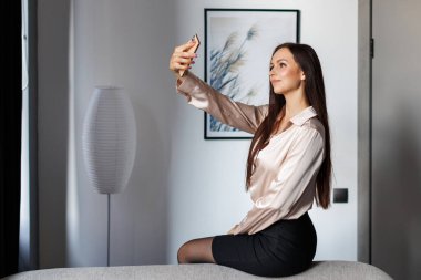 Evde bir selfie ile akıllı telefonunu alarak güzel bir esmer portresi