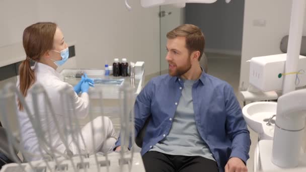 Blonde Female Dentist Dental Office Talking Male Patient Preparing Treatment — Vídeo de Stock