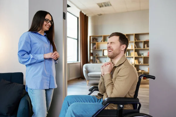 stock image A young handsome man in a wheelchair reacts very emotionally and touchingly to the news that his girlfriend told him.