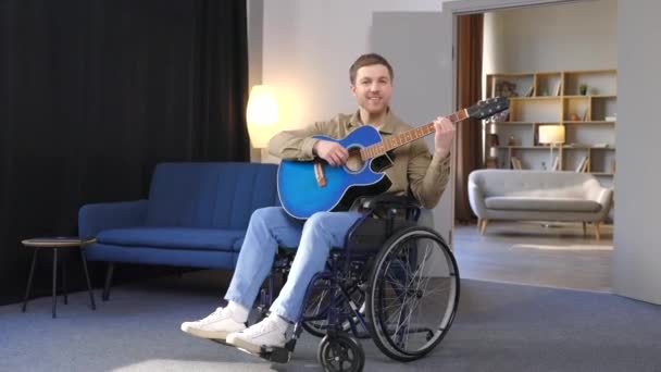 Красивий Чоловік Інвалідністю Сидить Інвалідному Візку Граючи Гітарі Вдома — стокове відео