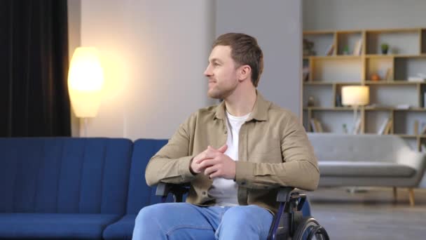 積極的なライフスタイル 障害者のケア 自宅でのリハビリテーションとサポート 居間の車椅子の若い白人男性 — ストック動画
