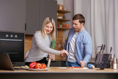 Beni rahat bırak. Bir kadın yemek hazırlıyor ve bir erkek onunla konuşuyor ve pişirme tarzından memnun değil.