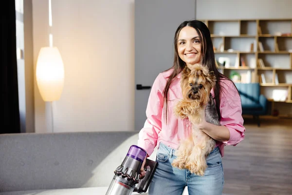 女とともに掃除機と犬で彼女の手真空でザリビングルーム — ストック写真