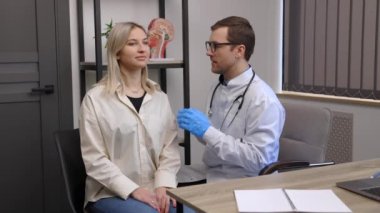 Otolaryngologist, ENT kliniğinde otoskop ya da auriskop kullanarak genç kadının kulağını kontrol ediyor. İşitme sınavı