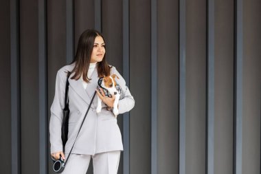 Güz gününde, açık havada köpek kostümü giymiş, en sevdiği tüylü, eğitimli, safkan Jack Russell Terrier köpeğine sarılan bir kadın. Sadık en iyi arkadaşlar